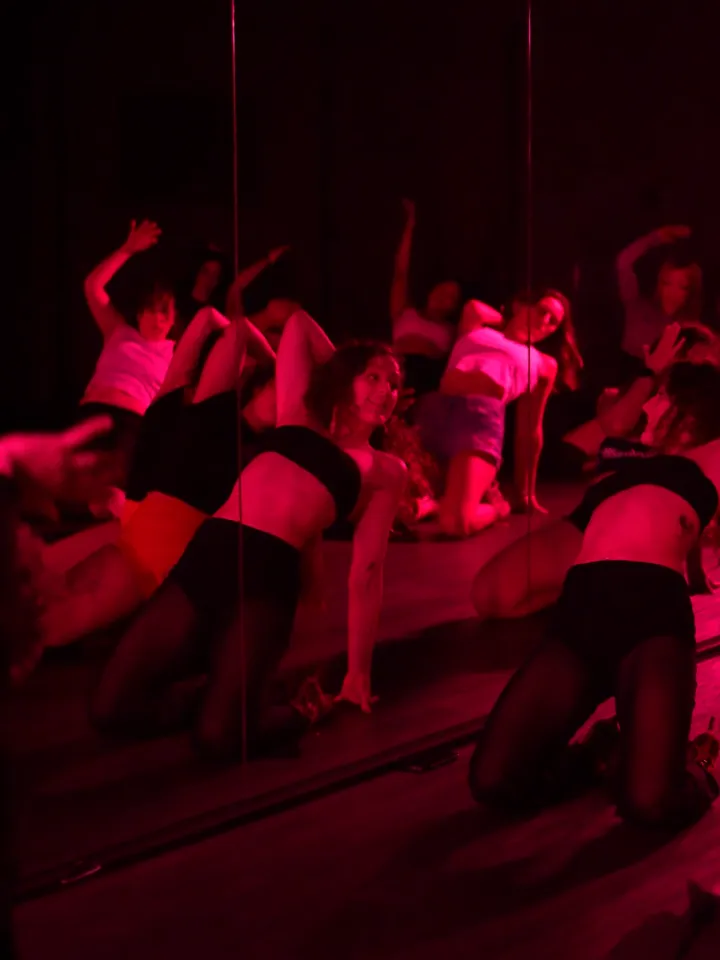 Clase de On Heels frente al espejo: el grupo haciendo la coreografía de rodillas, en tacos